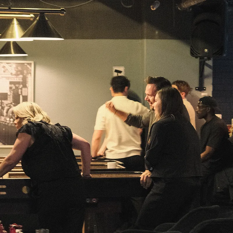 Ansatte spiller shuffleboard i baren